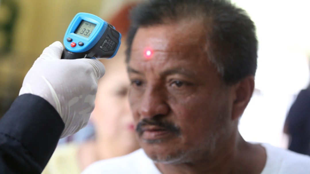 Foto: Personal médico toma la temperatura a ciudadanos en la calle. Getty Images