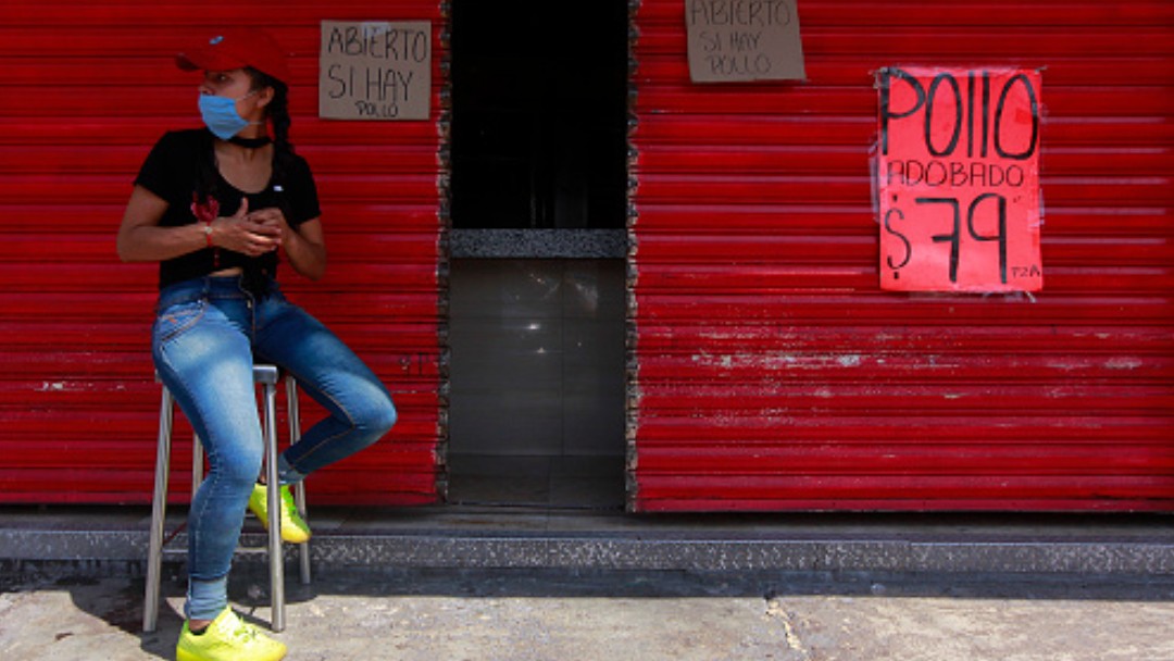 Foto: Una joven sentada a la espera de clientes en una pollería. Getty Images