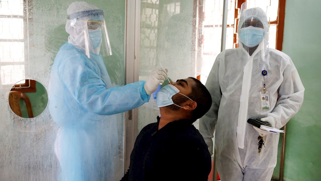 Un trabajador sanitario en Bangladesh usa una mascarilla protectora y un traje para recolectar una muestra por un posible caso de Covid-19. (Foto: EFE)