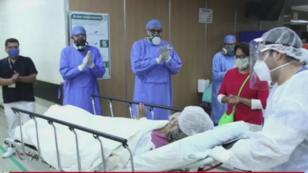 Una paciente sale en medio de aplausos por parte del personal sanitario tras recuperarse del coronavirus. (Foto: Noticieros Televisa)