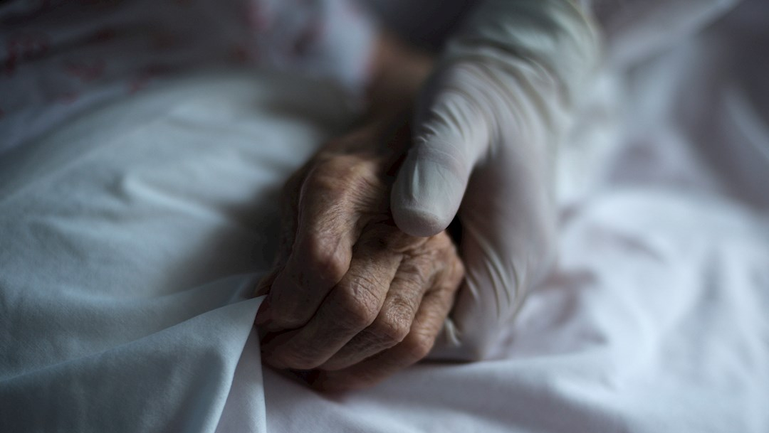 Fotografía que muestra la mano de un trabajador sanitario agarrando a una paciente enferma de coronavirus. (Foto: EFE)
