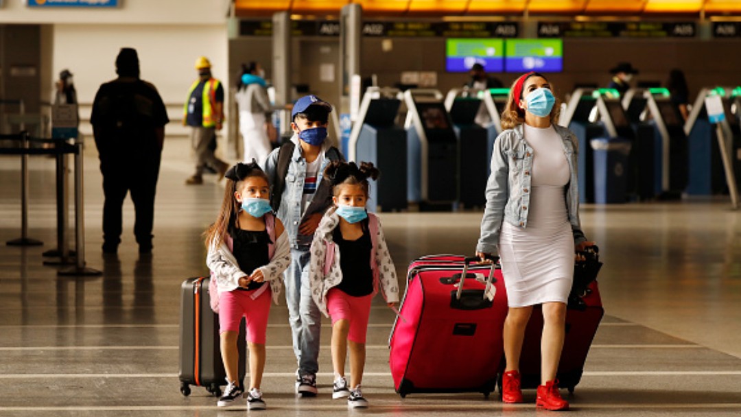 Una familia usa cubrebocas en el Aeropuerto Internacional de Los Angeles. Getty Images