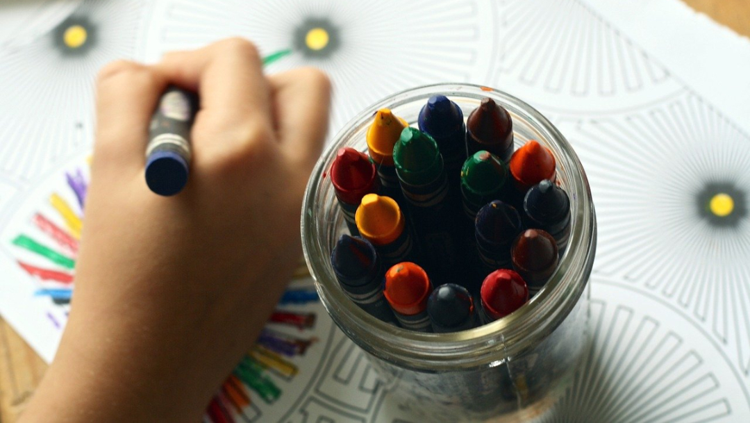 mano-de-niño-y-crayones-de-colores-para-pintar