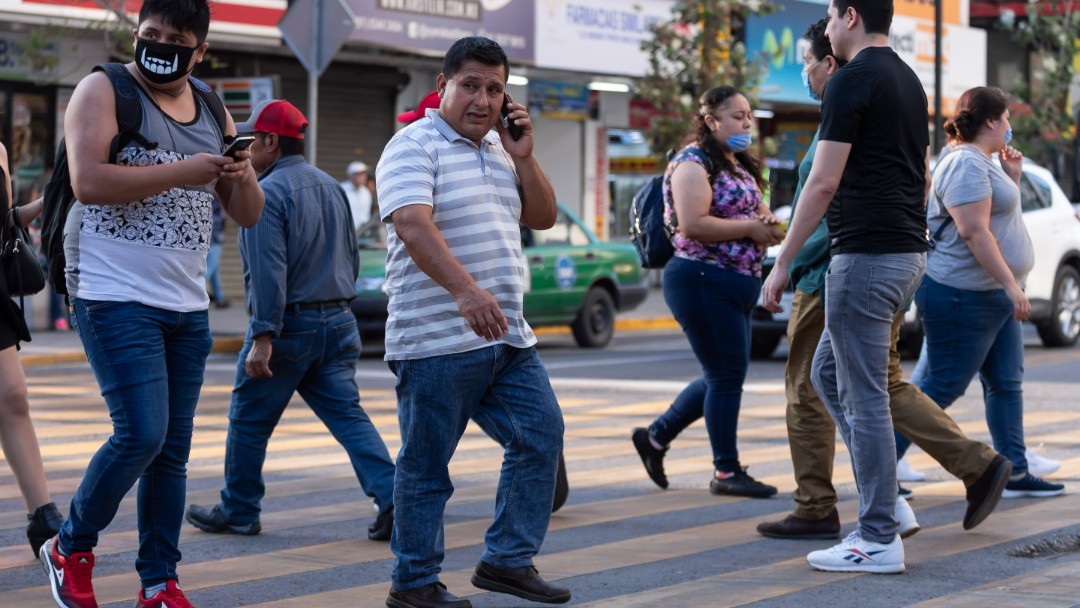 Personas con y sin cubrebocas caminan por una calle de Nuevo León. Getty Images