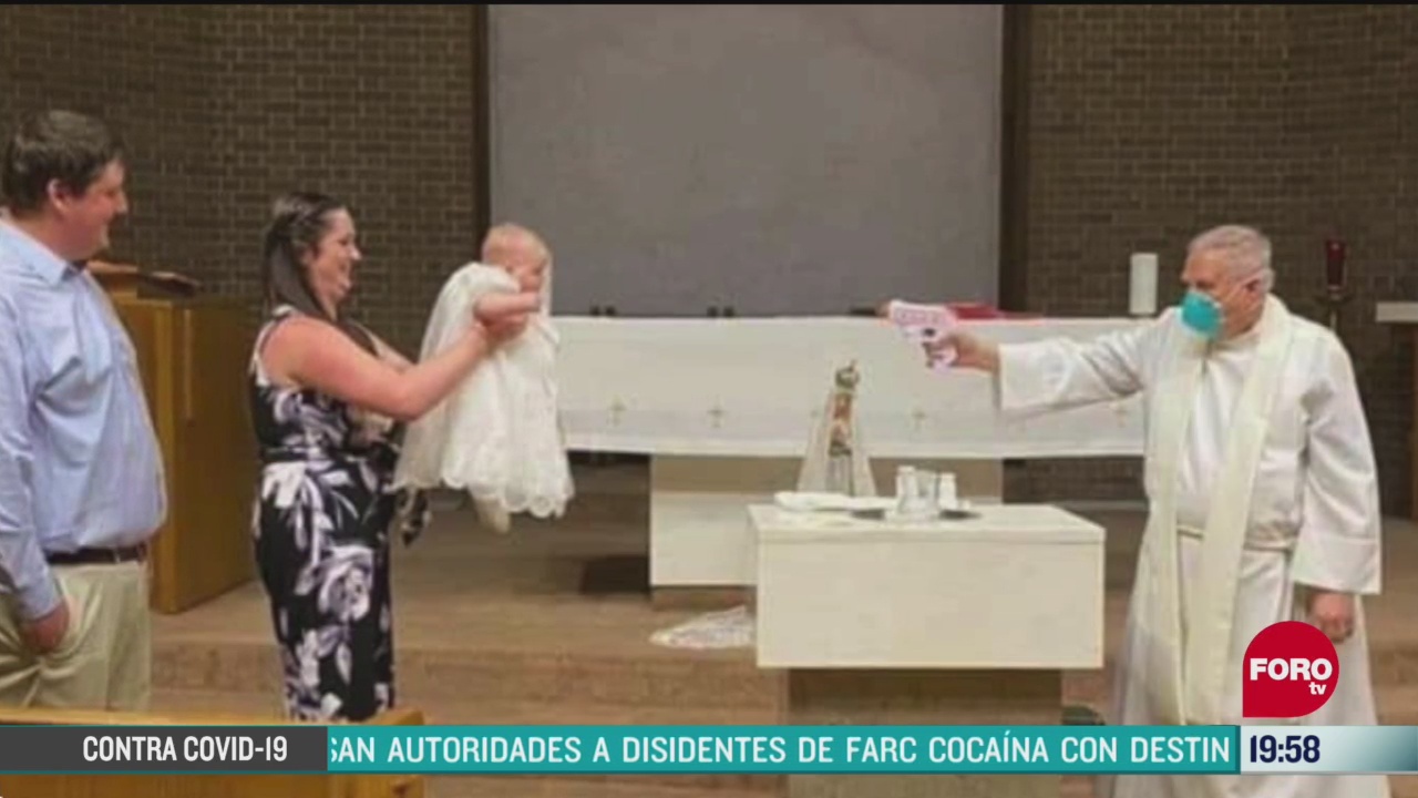 sacerdote usa pistola de agua para bautizar a un bebe