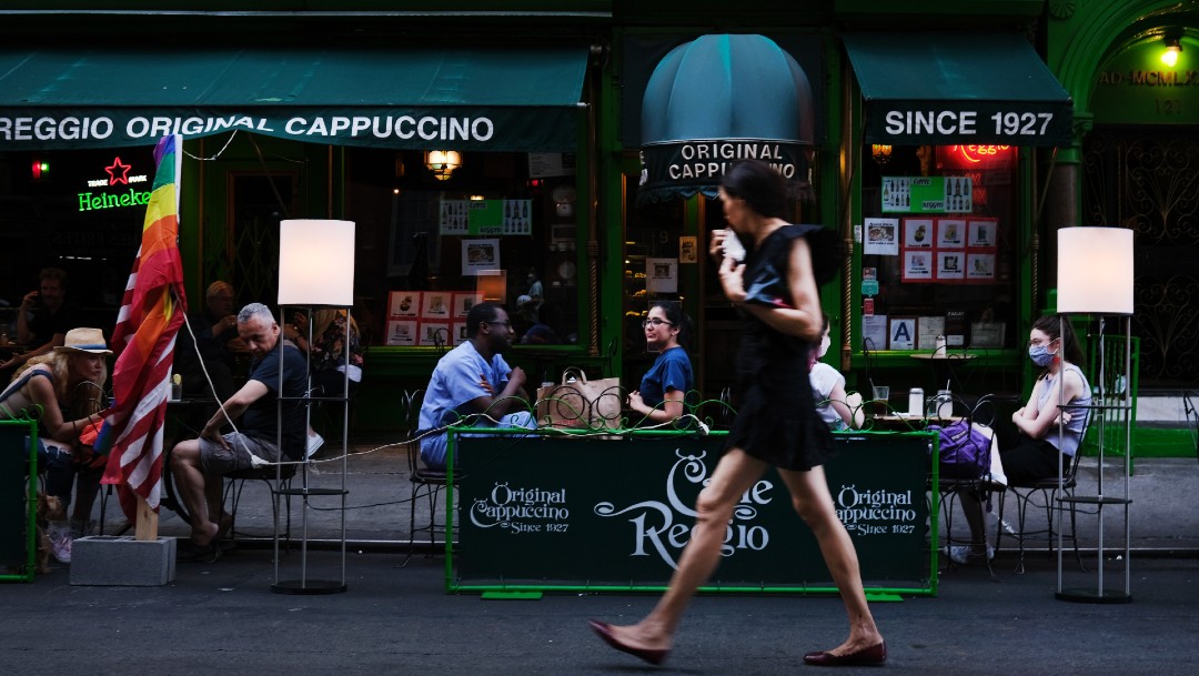 Mujer caminando frente a restaurante en Nueva York; Economía Estados Unidos