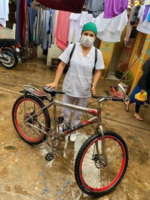 Foto de enfermera en Bolivia con bicicleta en inundación