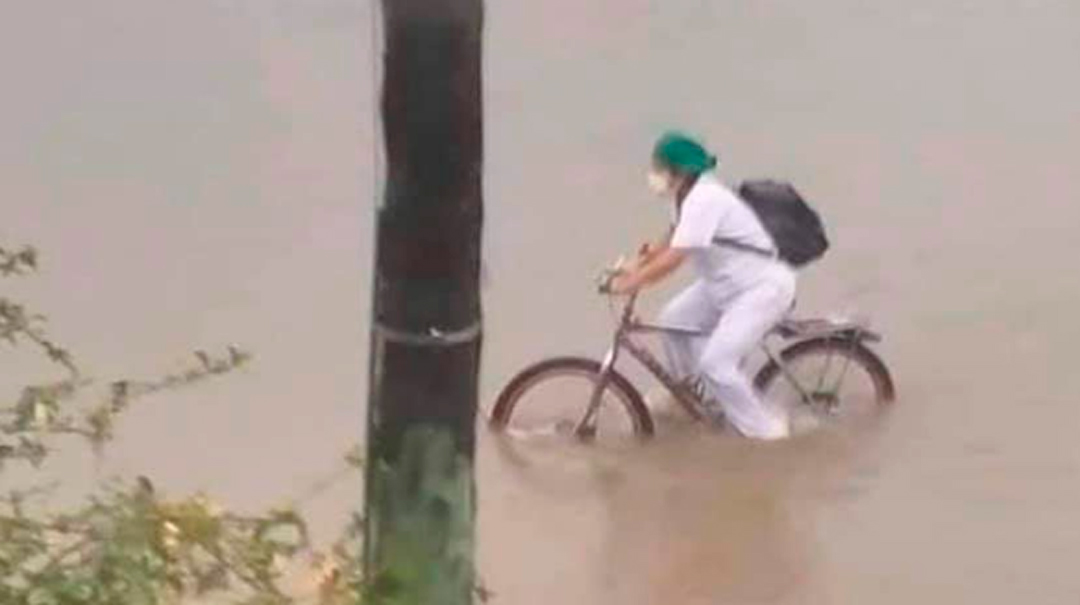 Enfermera en bicicleta durante inundación en Bolivia