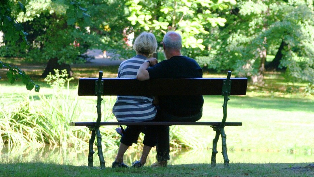 pareja-abuelitos-sentada-banca-parque