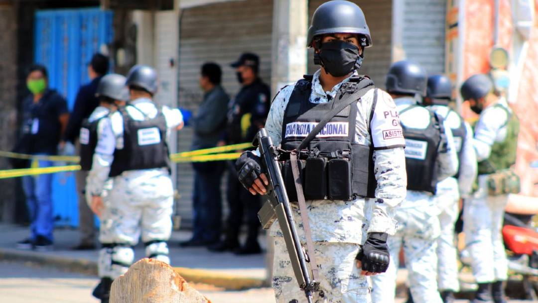 Elementos de la Guardia Nacional resguardan la zona donde fue hallado el cuerpo de una persona en un taller eléctrico en Jiutepec. (Foto: EFE)