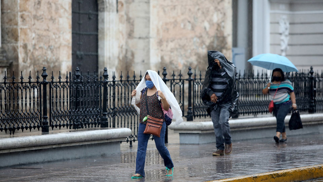 Las personas se protegen de la lluvia que se registra en algunos estados de México. (Foto: Cuartoscuro)