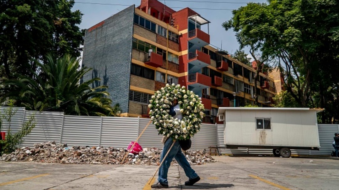 Un hombre carga una corona de flores. Getty Images