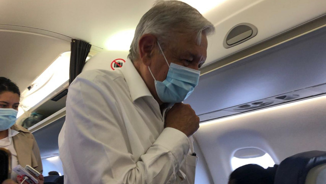 El presidente Andrés Manuel López Obrador usando cubrebocas al abordar su vuelo