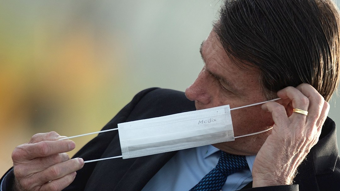 El presidente de Brasil, Jair Bolsonaro, se retira el cubrebocas