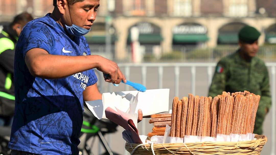 Un hombre vende churros en el centro histórico de la CDMX durante la pandemia por coronavirus. (Foto: EFE)