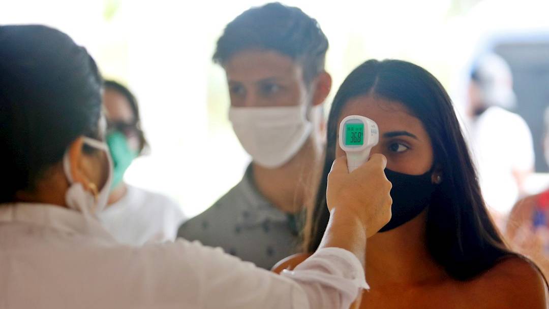 Una trabajadora de la salud toma la temperatura a visitantes del Hotel Meliá Sol Palmeras de Varadero, en Cuba