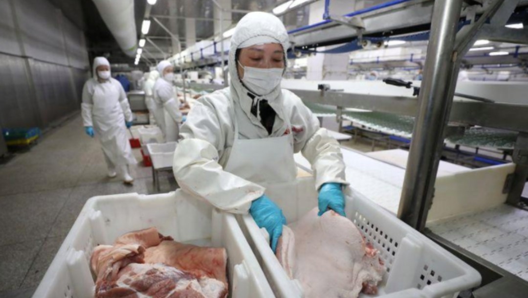 Empleados trabajan en una planta de procesamiento de carne de cerdo en Huaian, provincia de Jiangsu, China