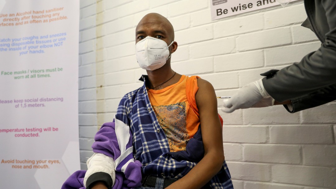 Hombre con cubrebocas es vacunado en ensayo de vacuna contra el COVID