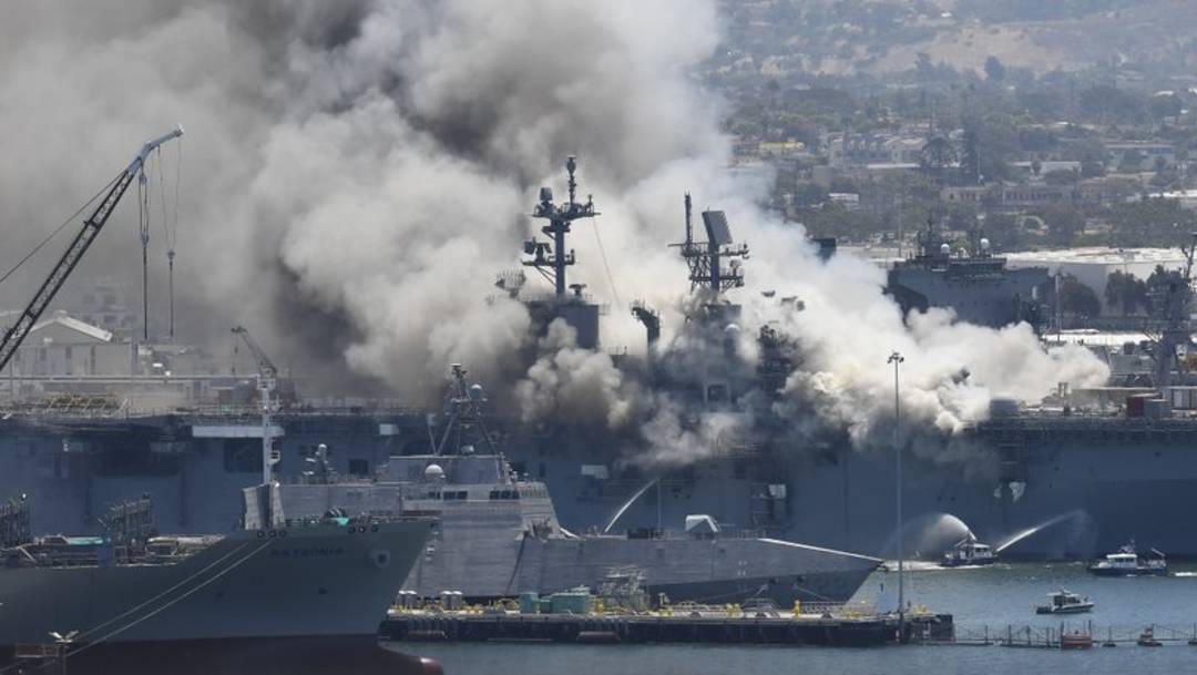 Una enorme columna de humo se eleva sobre el buque USS Bonhomme Richard en la base naval de San Diego el domingo 12 de julio de 2020 tras un incendio y explosión a bordo