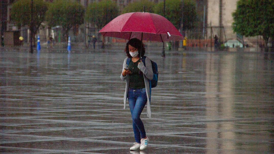 Una joven se protege de la lluvia que se registra en la Ciudad de México