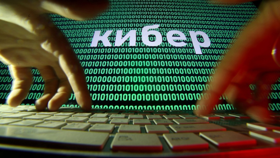 Manos en teclado de computadora, con letrero en ruso