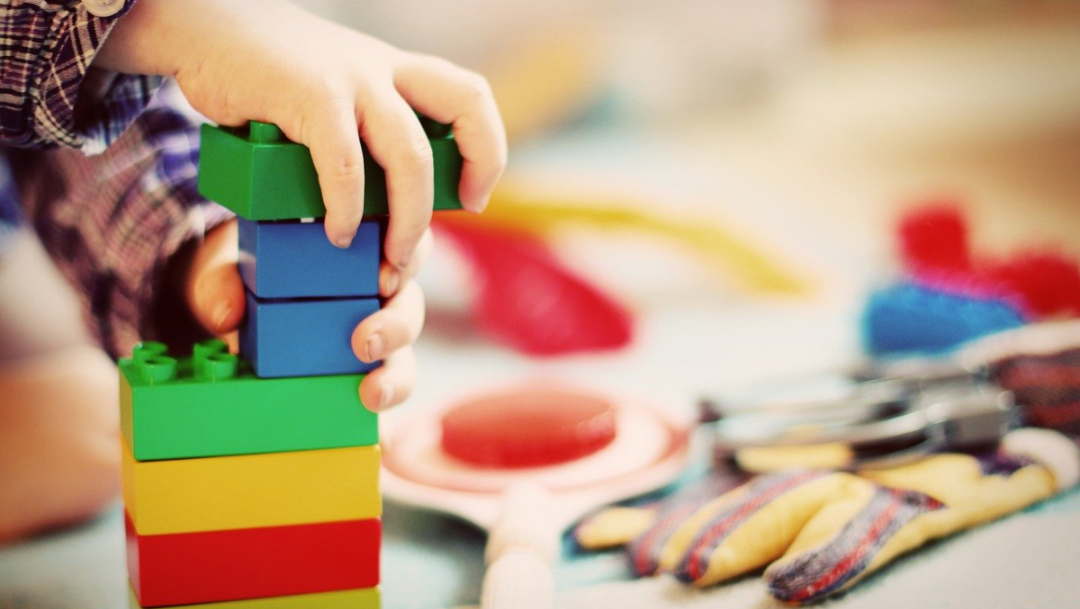 Mano niño jugando con bloques de colores para nota sobre niño curado de cáncer
