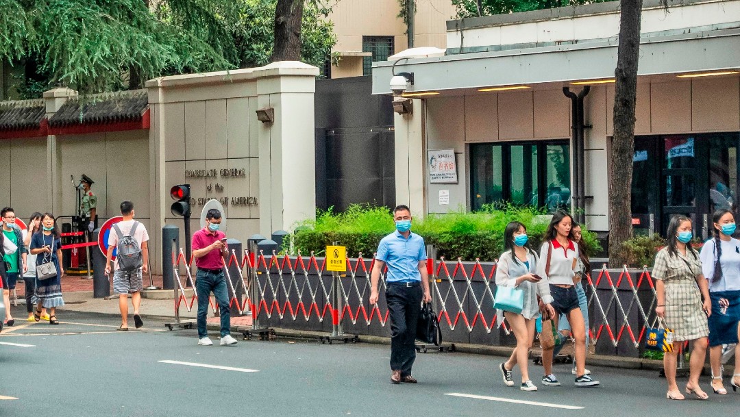 Personas caminando frente al consulado estadounidense en Chengdu, China