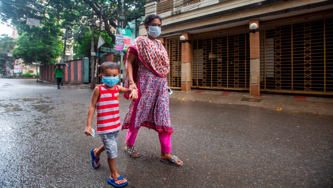 Un niño y una mujer caminan con cubrebocas en Dhaka, Bangladesh