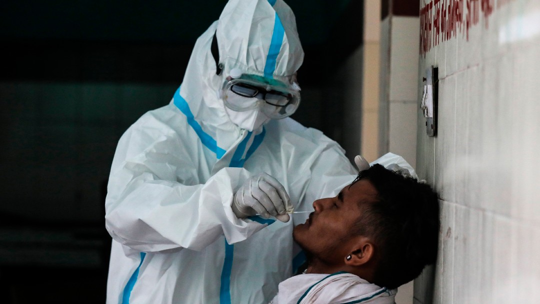 Un trabajador de salud toma muestra de coronavirus a hombre en India