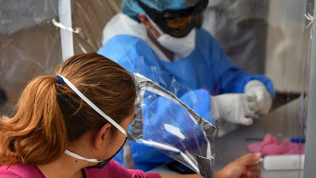 Empleados de la Secretaría de Salud practican pruebas a personas en un pabellón instalado en la Central de Abastos, una zona considerada de alto riesgo de contagio