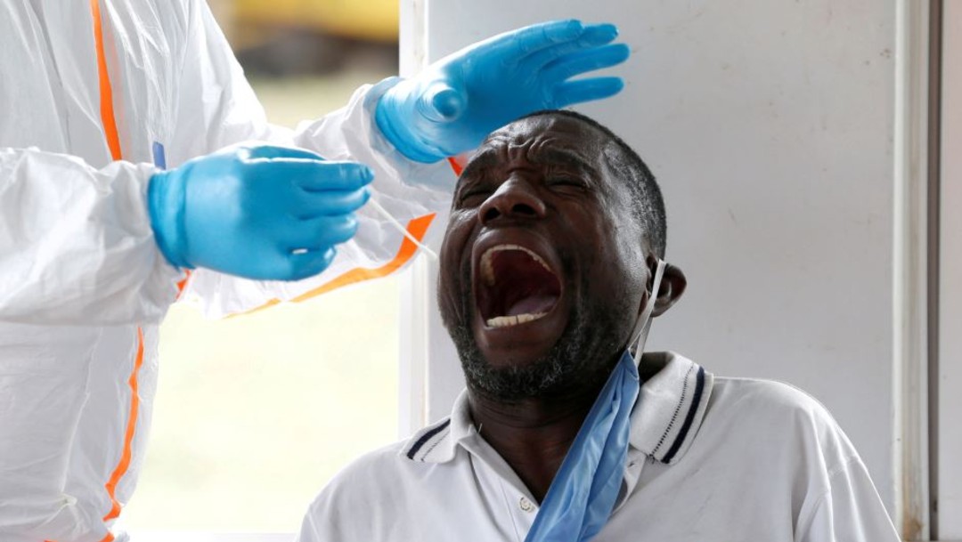 Empleado sanitario toma muestra de coronavirus a hombre en África