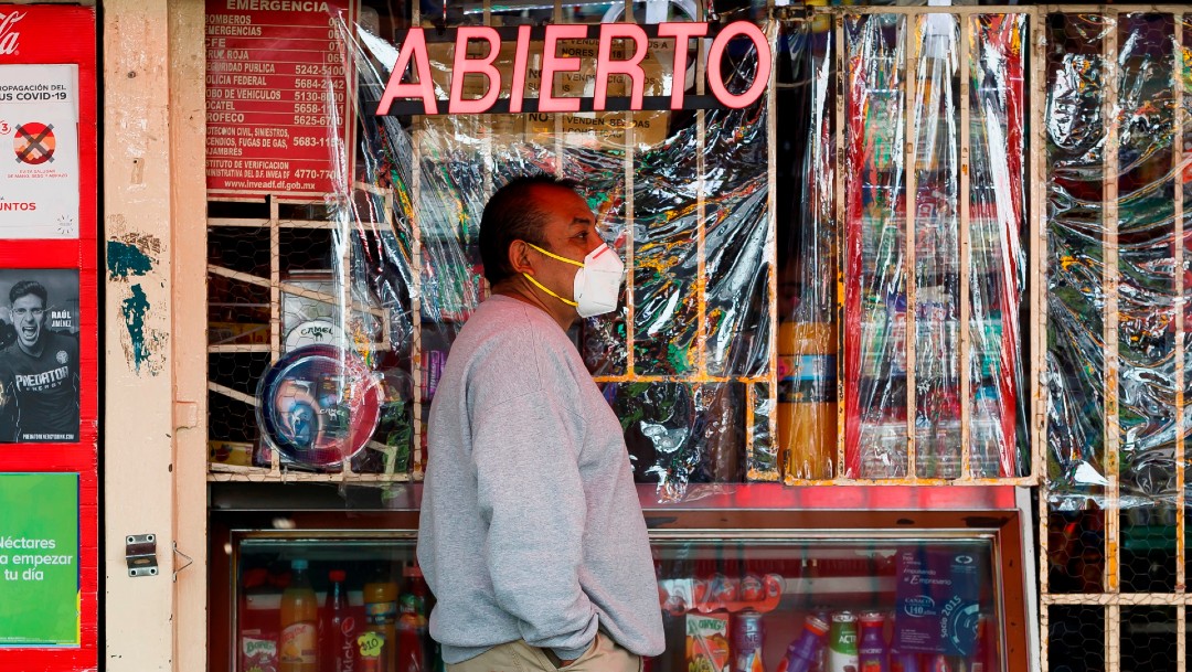 Hombre con cubrebocas frente a una tienda en México