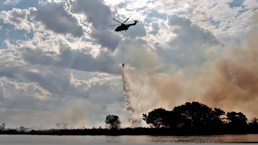 Un helicóptero realiza labores de lucha contra incendios, cerca de la ciudad de Corumbá donde se encuentra el pantanal brasileño de Mato Grosso, uno de los mayores humedales del planeta