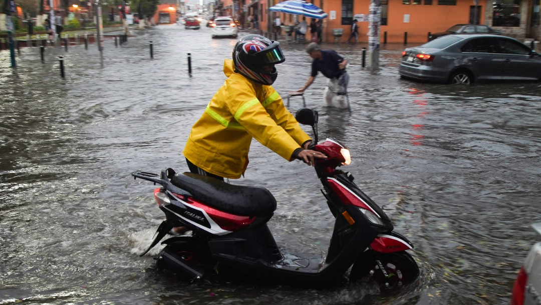 Fotografía que muestra calles inundadas y vehículos varados por la intensa lluvia