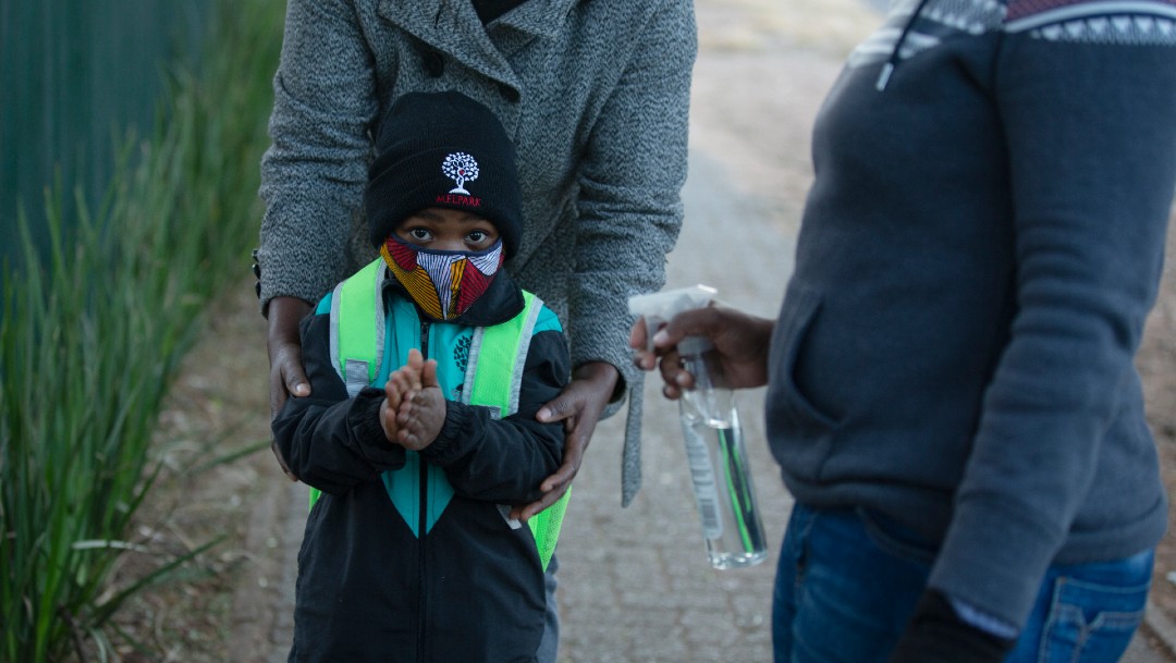 Niño limpia con gel sus manos en Sudáfrica