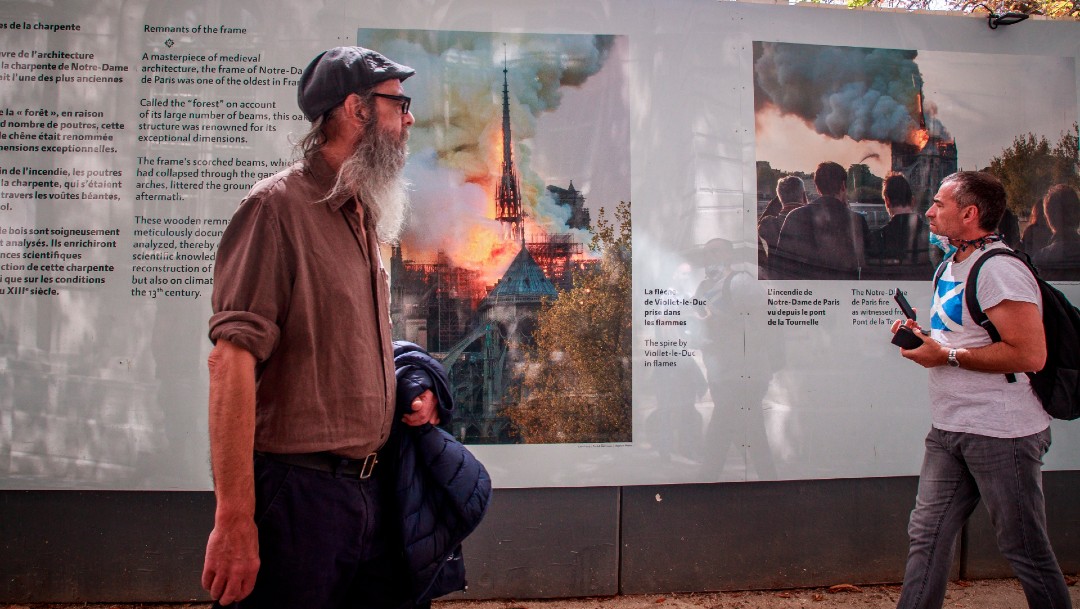Personas sin cubrebocas observan exposición sobre reconstrucción de Notre Dame en París