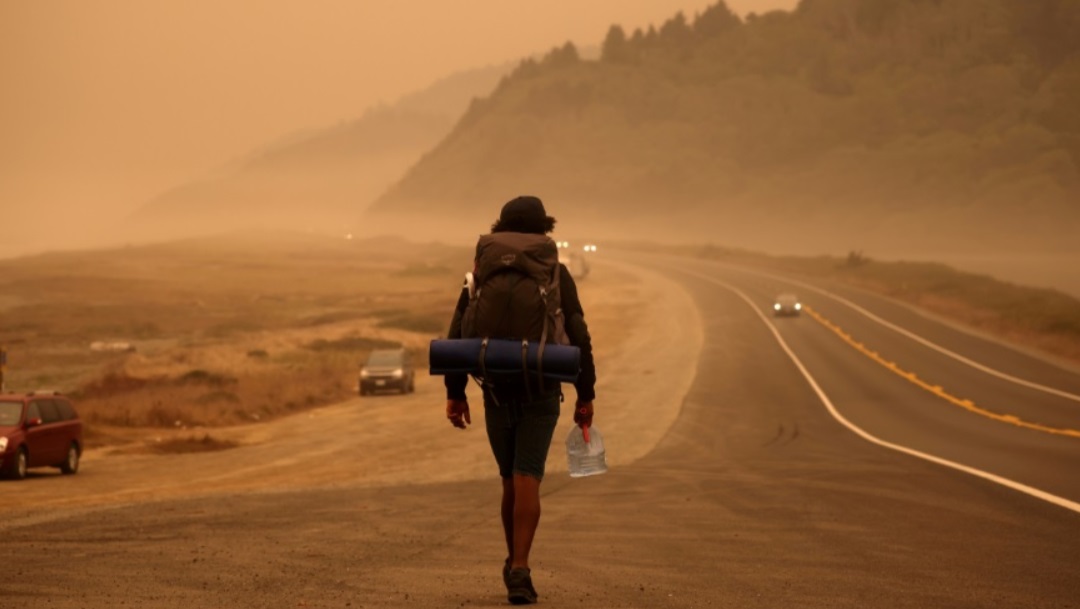 Un hombre camina entre una densa de humo en California