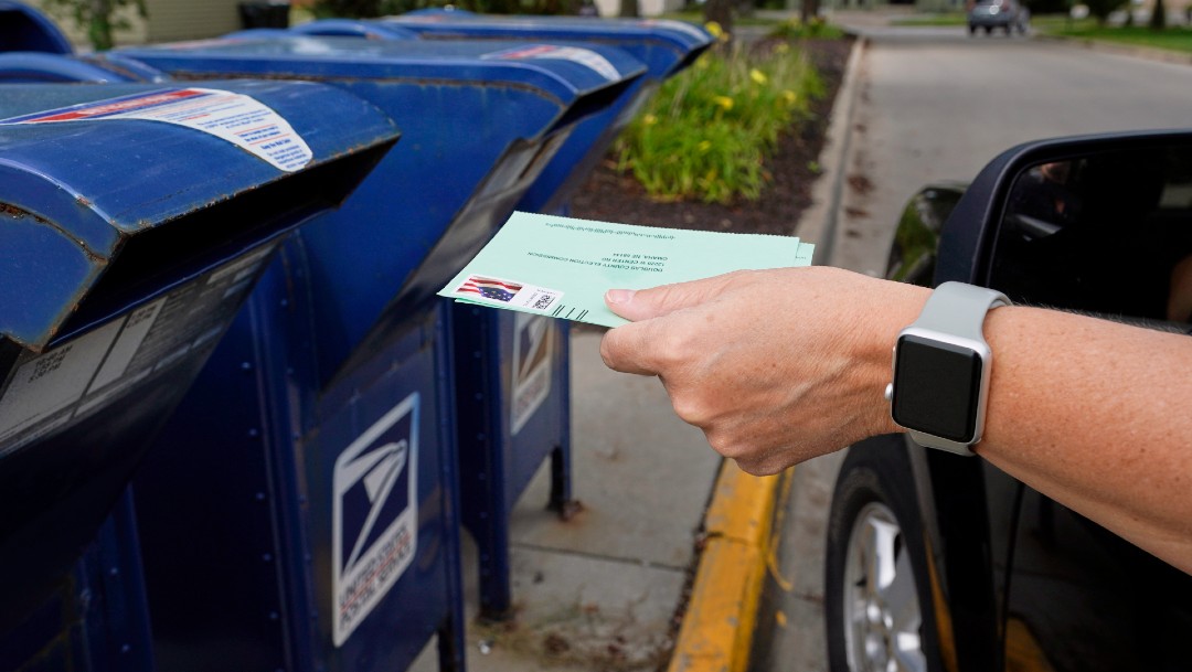 Persona colocando un documento en buzón de correo en Estados Unidos
