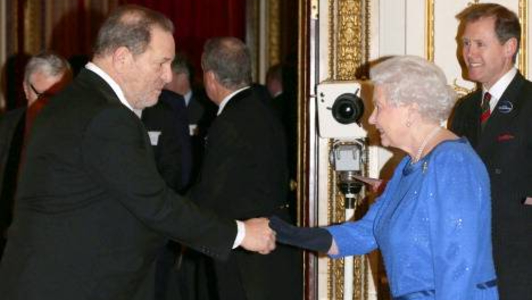Fotografía que muestra a la reina Isabel saludando al cineasta Harvey Weinstein
