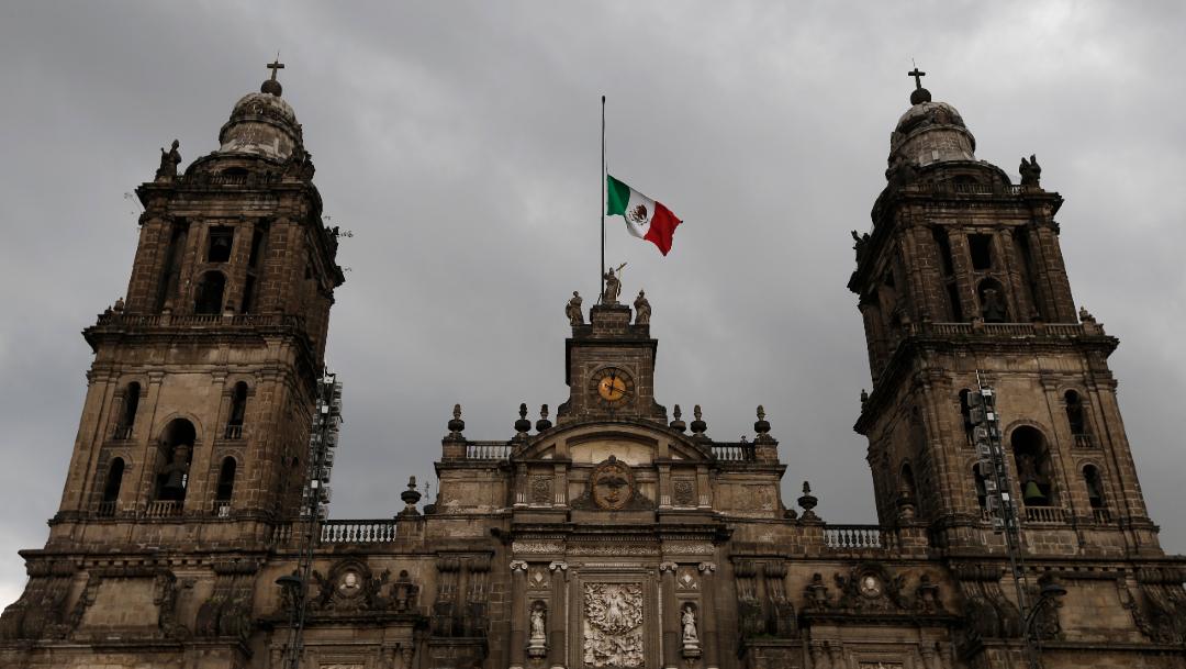 Una bandera mexicana ondea en la Catedral Metropolitana, en la CDMX. (Foto: AP)