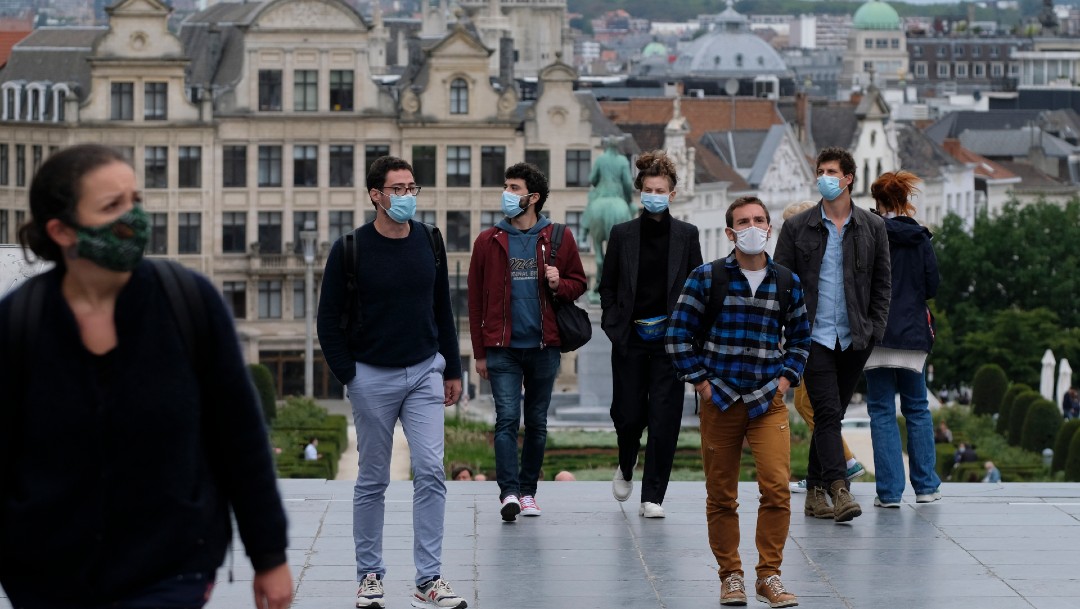 Varias personas con mascarilla pasan por la Grand Place de Bruselas