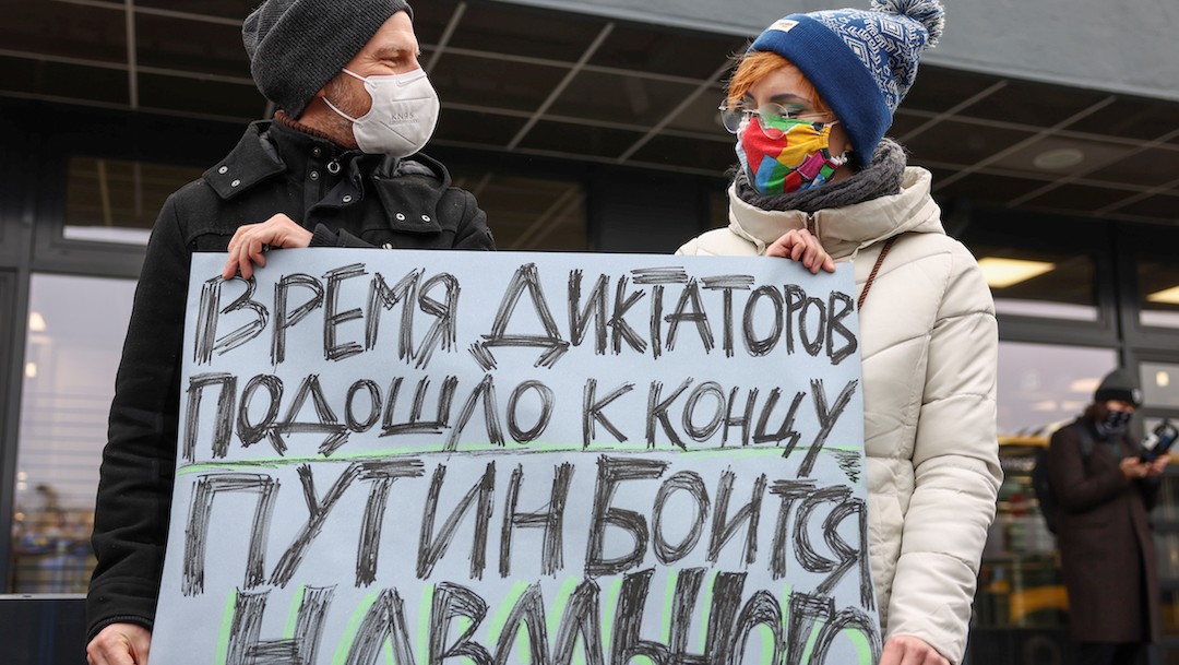 Una pareja sostiene una pancarta que dice: “Los tiempos de los dictadores llegan a su fin, Putin le tiene miedo a Navalny” (Reuters)