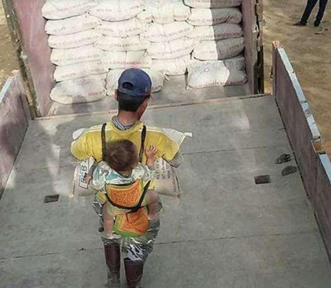 Albañil carga a su hijo en la espalda mientras trabaja