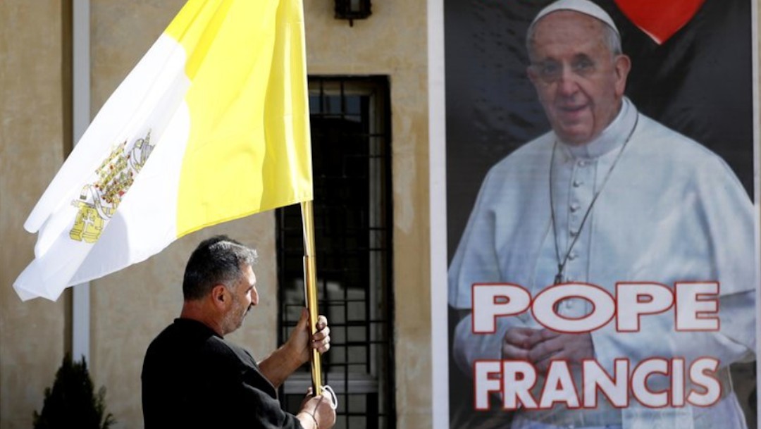 Un hombre en Irak sostiene una bandera del Vaticano (AP)