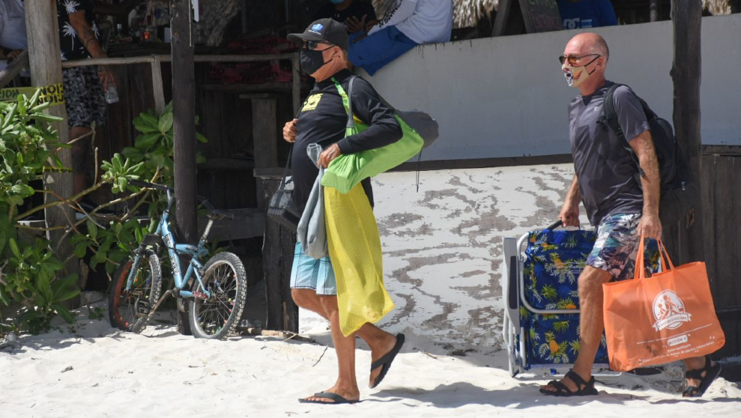Turistas disfrutan de las cálidas aguas del Caribe mexicano