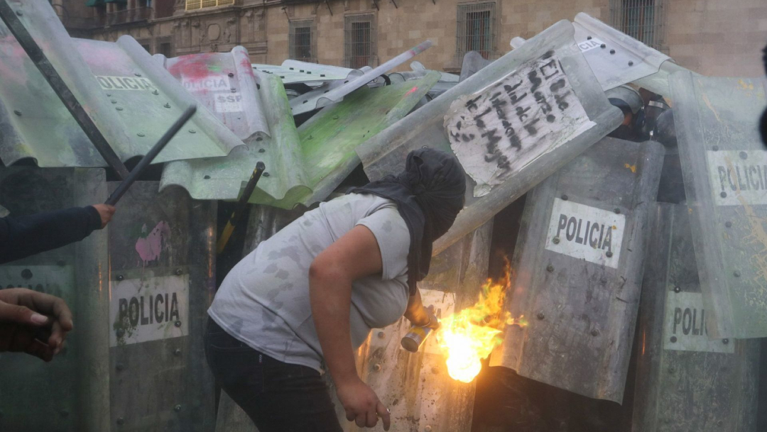 Una mujer les avienta fuego con un spray a los policías durante la marcha del 8M en la Ciudad de México