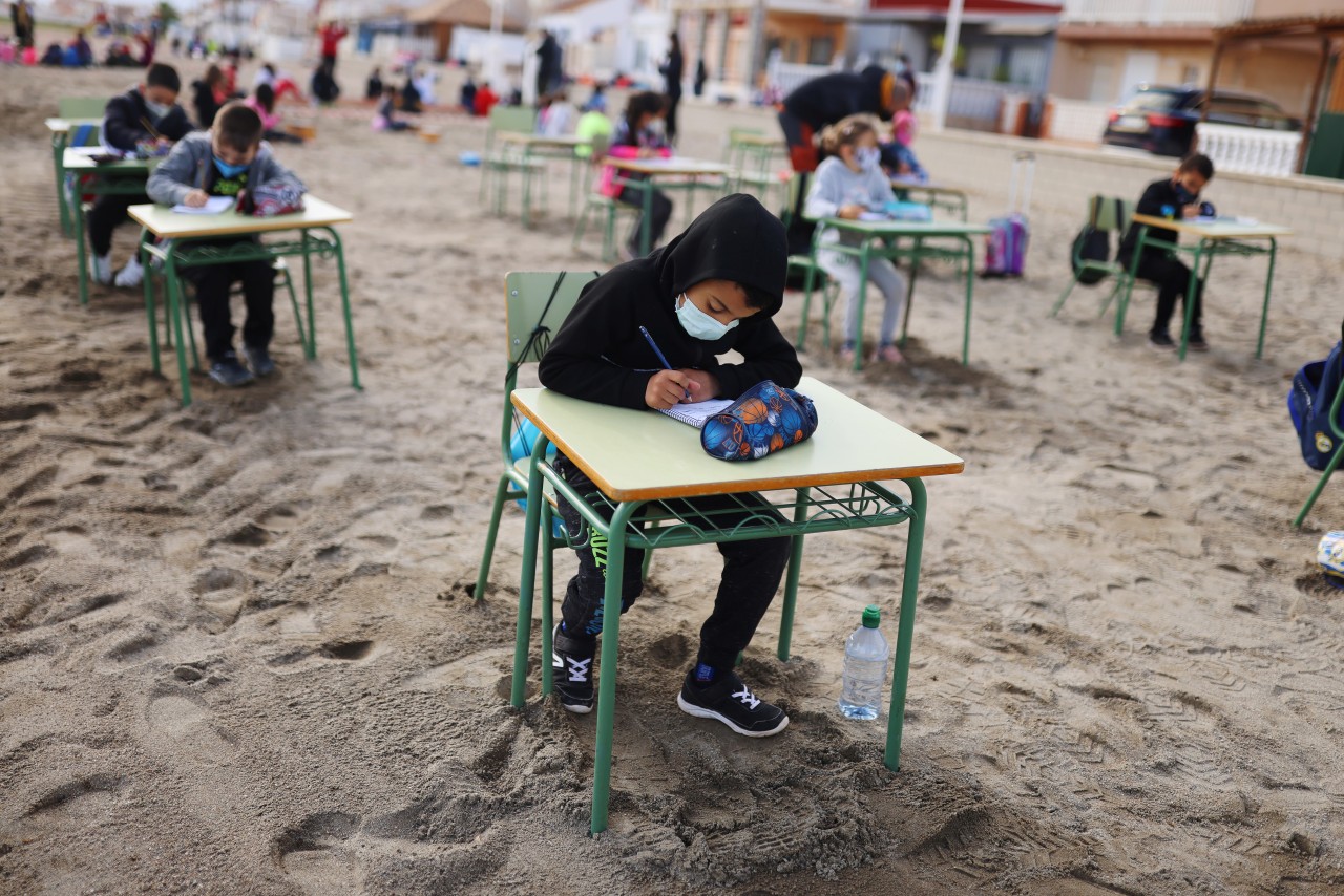 Niños toman clases presenciales en la playa en España