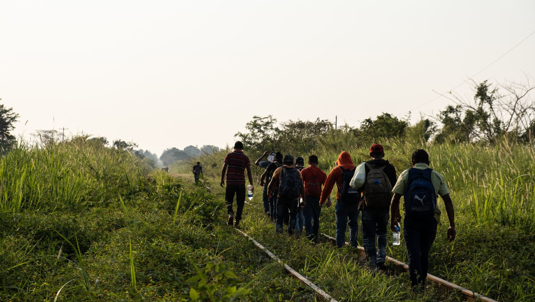 Un grupo de migrantes hondureños retoma su camino sobre las vías del tren desde la estación de trenes Chontalpa, Chiapas