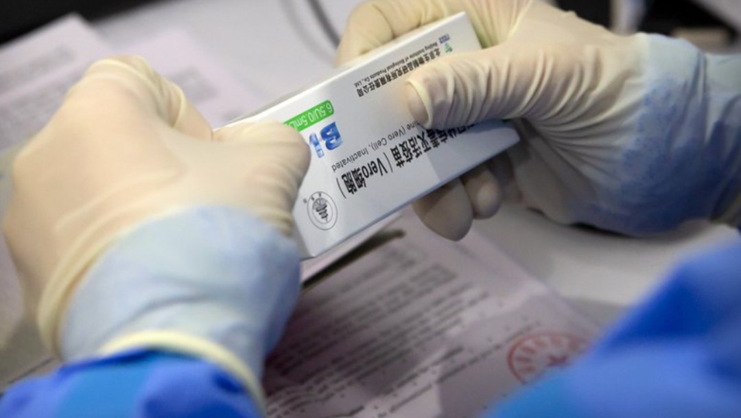 Un trabajador abre una caja de vacuna contra el coronavirus fabricada por una filial de Sinopharm (AP)