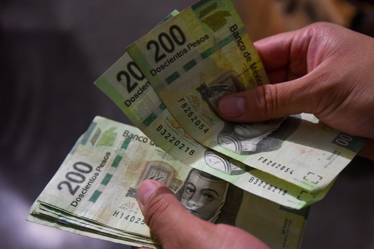 Fotografía que muestra a una persona contando billetes.